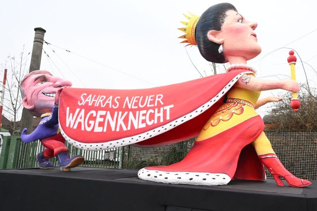 «Sahras neuer Wagenknecht» steht auf dem Umhang einer Figur auf einem Mottowagen, der zum Rosenmontagszug in Düsseldorf gefahren wird.