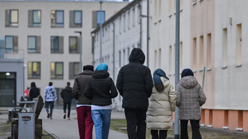 Migranten gehen über das Gelände der Zentralen Erstaufnahmeeinrichtung für Asylbewerber des Landes Brandenburg in Eisenhüttenstadt.