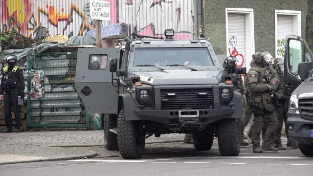 Polizisten an einem gepanzerten Fahrzeug.