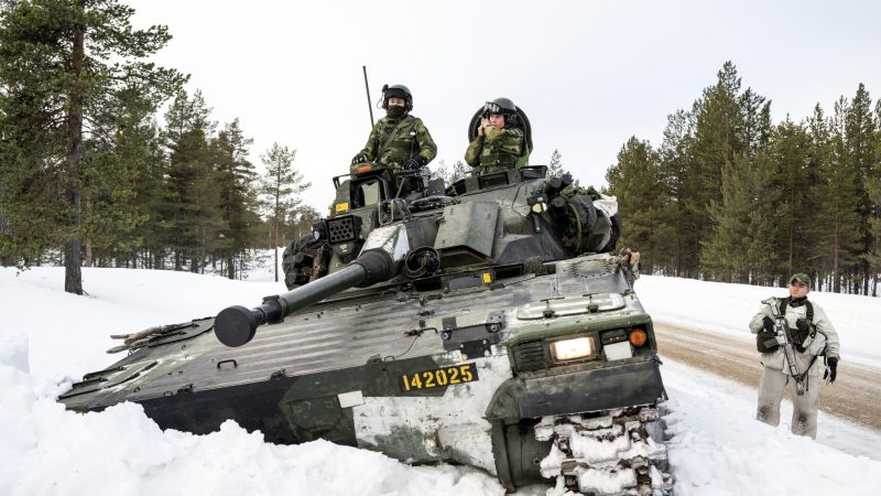 Schwedische Soldaten auf einem Panzer nehmen an einer gemeinsamen Übung mit finnischen Jagdeinheiten teil.