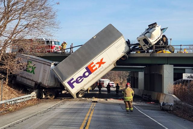 Interstate Richtung New York: Feuerwehrleute untersuchen die Unfallstelle, an der ein LKW auf einer Brücke umgestürzt ist.