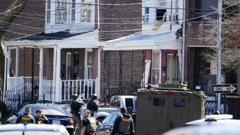 Polizisten umstellen das Haus in Trenton, in dem sich der mutmaßliche Täter mit seinen Geiseln verschanzt hat.
