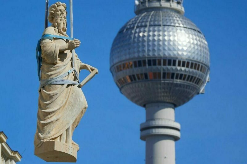 Heilige Montage: Eine steinerne Skulptur des Propheten Jeremias wird in Berlin auf das Dach des Humboldt Forums gehoben. Insgesamt acht biblischen Propheten zieren die Kuppel-Balustrade des Gebäudes.