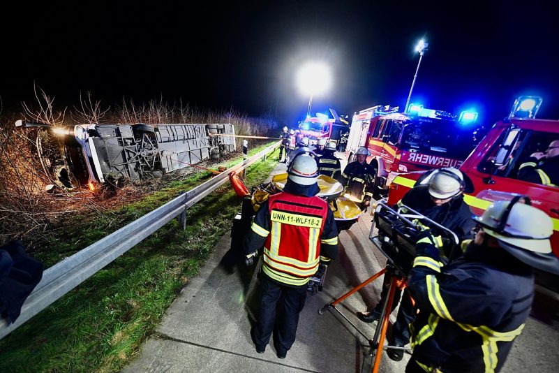 Einsatzkräfte der Feuerwehr arbeiten an einer Unfallstelle auf der Autobahn 44 (A44) an einem verunfallten Bus.