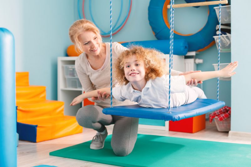 In der Ergotherapie werden verschiedene Methoden eingesetzt, hier übt ein Junge auf einer Therapieschaukel. Foto: iStock