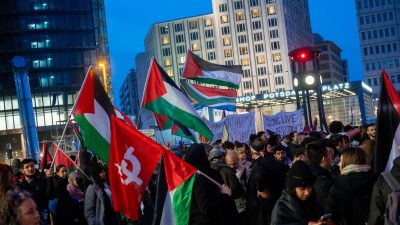 Teilnehmer einer pro-Palästina Demonstration stehen auf dem Potsdamer Platz in Berlin.