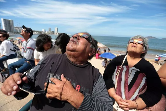 Menschen versammeln sich unter anderem im Hafen von Mazatlán, Mexico, um die totale Sonnenfinsternis beobachten.