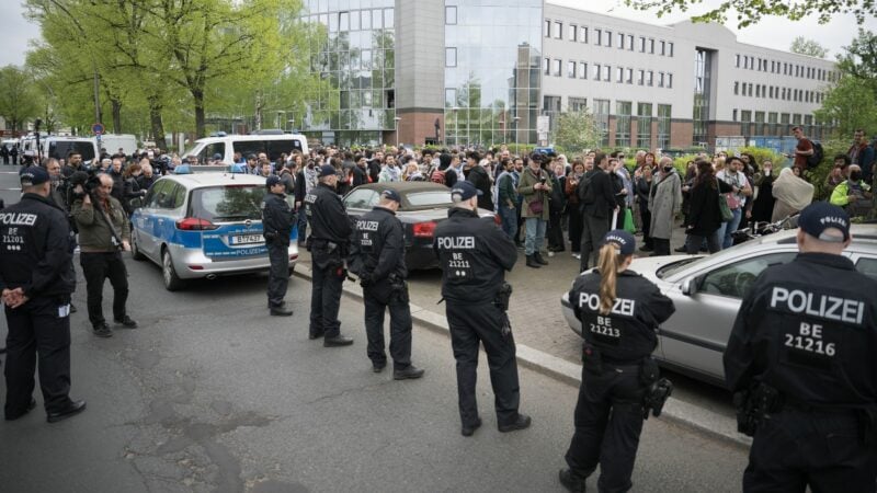 Teilnehmer des «Palästina-Kongresses» und Polizisten stehen vor der Veranstaltungshalle in Berlin-Tempelhof.