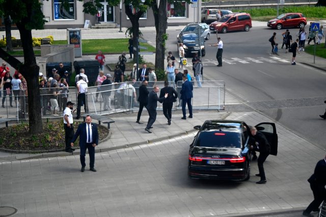 Leibwächter bringen den slowakischen Regierungschef Robert Fico nach dem Attentat in einem Auto in Sicherheit.