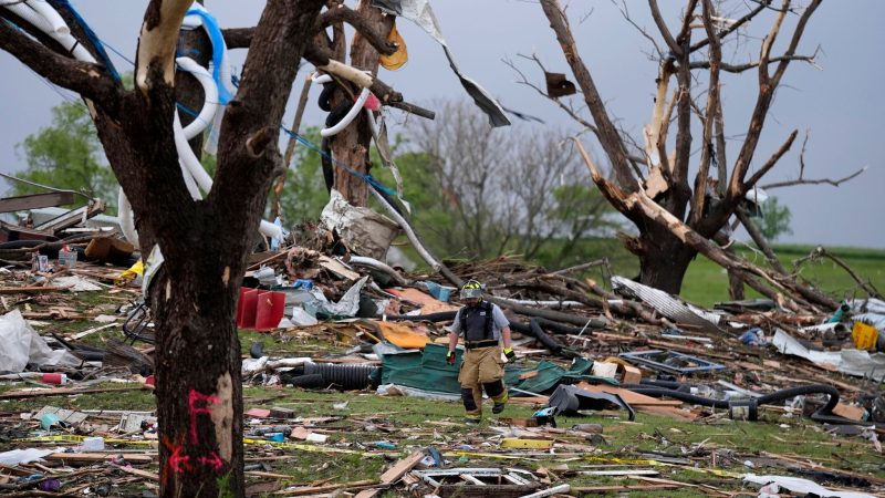 Ein Feuerwehrmann geht in Greenfield, Iowa, zwischen von einem Tornado zerstörten Häusern umher.