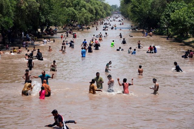 Menschen kühlen sich in Lahore bei heißem Wetter in einem Kanal ab.