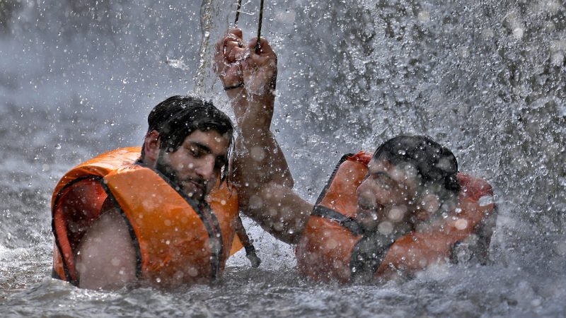 Pakistanische Männer kühlen sich in einem Bach ab, während die Temperaturen in Islamabad 39 Grad Celsius erreichen.
