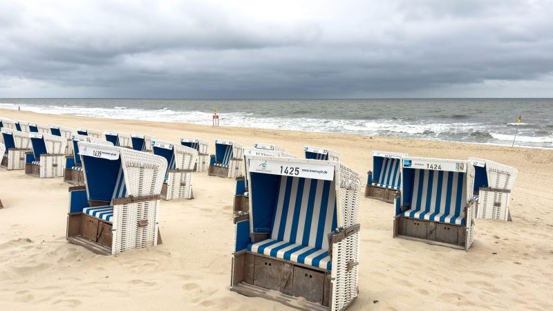 Strandkörbe bei bewölktem Himmel und Temperaturen um 15 Grad Celsius am Strand von Westerland.