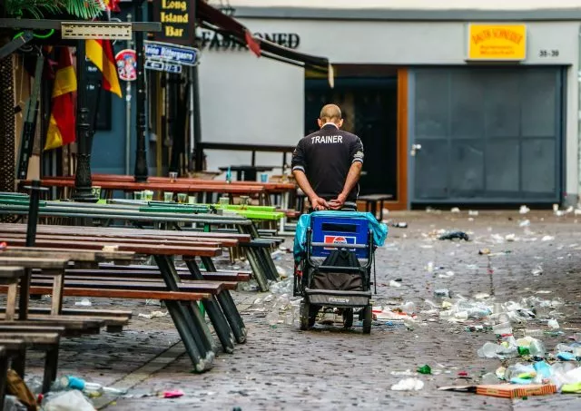 Nach den Übertragungen zur Fussballeuropameisterschaft ist vor dem Aufräumen: Ein Pfand-Flaschensammler nutzt die Hinterlassenschaften in den Morgenstunden in Frankfurt und hofft auf Einkünfte.