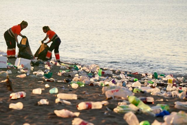 Reinigungskräfte sammeln am Strand von La Malagueta nach der kürzesten Nacht des Jahres Müll ein. <yoastmark class=