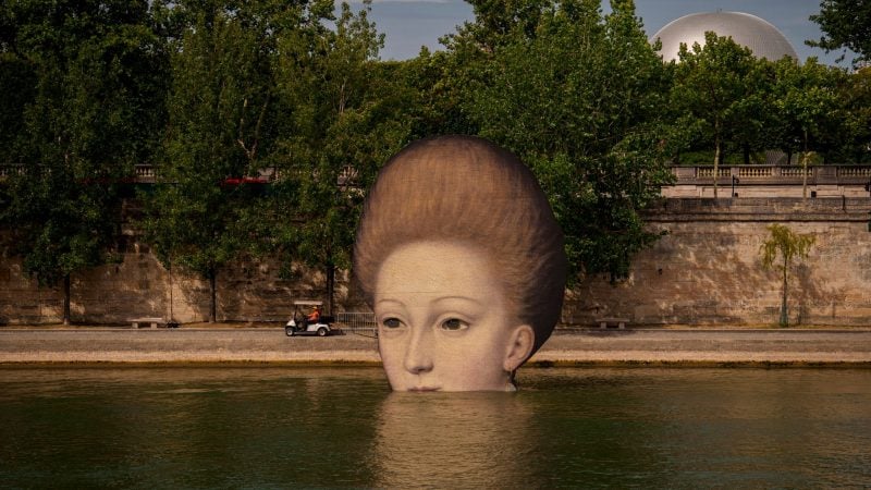 Wer schaut denn da aus dem Wasser:  Reproduktionen von Kunstwerken sind entlang der Seine in Paris für die Eröffnungsfeier der Olympischen Sommerspiele 2024 aufgestellt.