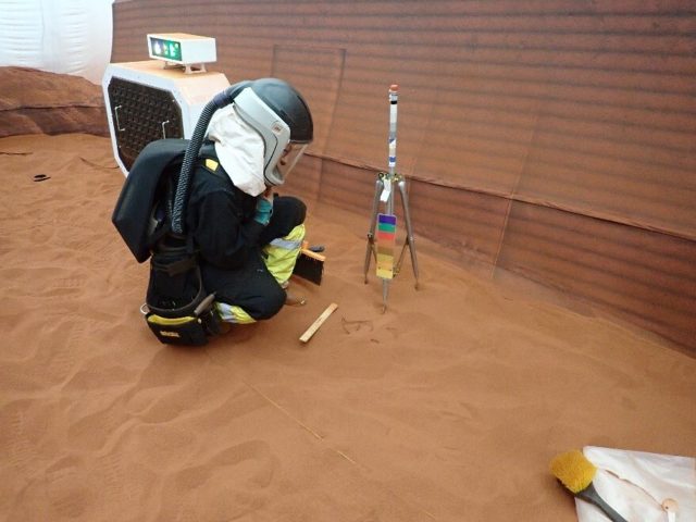 Ein CHAPEA-Besatzungsmitglied nimmt an einem simulierten "Marswalk" im Inneren der 1.200 Quadratmeter großen Anlage teil. Der Platz ist mit rotem Sand gefüllt, um die Marslandschaft zu imitieren.