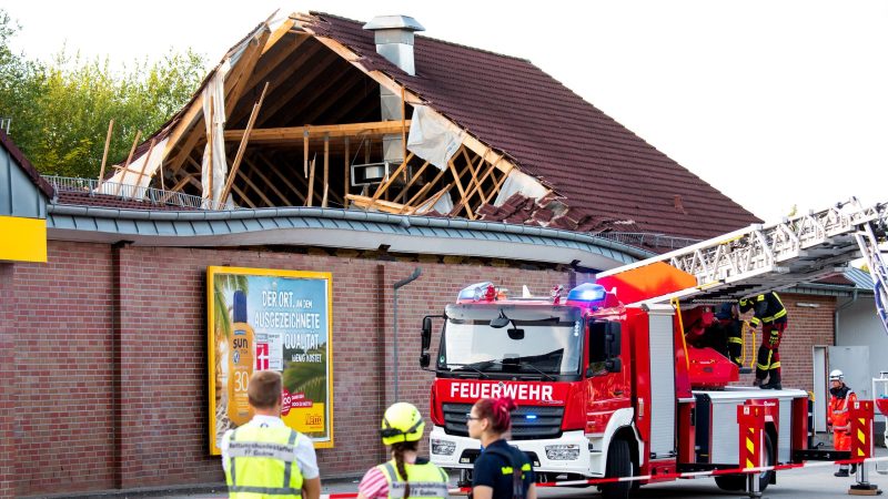 Einsatzkräfte stehen vor dem eingestürzten Supermarktdach in Ratzeburg.