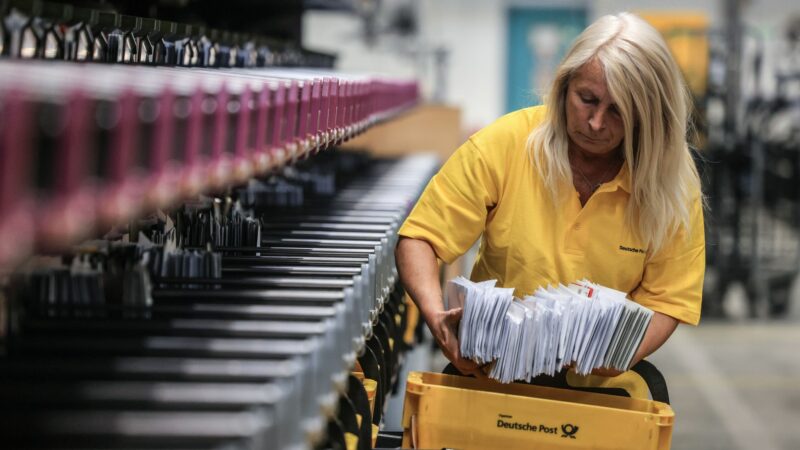 Eine Mitarbeiterin der Deutschen Post sortiert Briefe in einem Briefverteilzentrum.