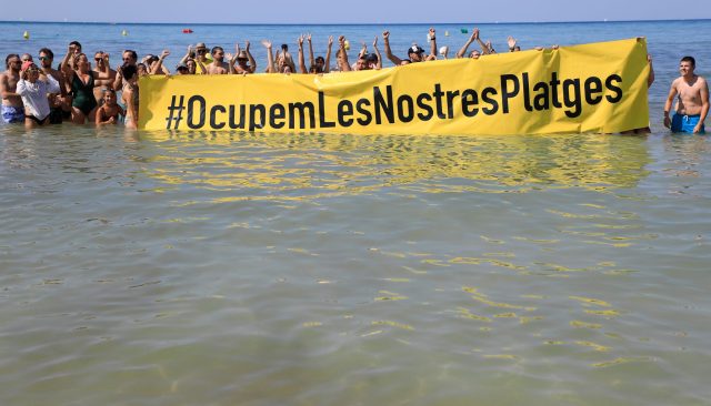 Rund 100 Aktivisten beteiligten sich an der Protestaktion. Überraschte Strandurlauber machten Fotos.