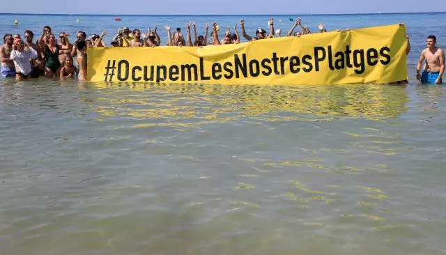 Rund 100 Aktivisten beteiligten sich an der Protestaktion. Überraschte Strandurlauber machten Fotos.