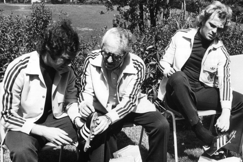 Adi Dassler (Mitte) galt lange Zeit als Pionier der Sportschuh-Welt. Das von ihm gegründete Unternehmen Adidas wird 75 Jahre alt. (Archivbild)