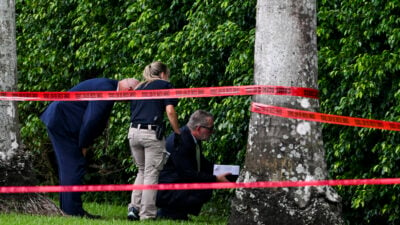 TOPSHOT - Law enforcement officials work at the crime scene outside the Trump International Golf Club in West Palm Beach, Florida, on September 16, 2024, following Sunday's attempted assassination on former US President and Republican presidential candidate Donald Trump. Ryan Wesley Routh, 58, was charged on Monday with possession of a firearm as a convicted felon and possession of a firearm with an obliterated serial number at his initial court appearance. (Photo by CHANDAN KHANNA / AFP) (Photo by CHANDAN KHANNA/AFP via Getty Images)