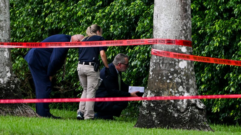 TOPSHOT - Law enforcement officials work at the crime scene outside the Trump International Golf Club in West Palm Beach, Florida, on September 16, 2024, following Sunday's attempted assassination on former US President and Republican presidential candidate Donald Trump. Ryan Wesley Routh, 58, was charged on Monday with possession of a firearm as a convicted felon and possession of a firearm with an obliterated serial number at his initial court appearance. (Photo by CHANDAN KHANNA / AFP) (Photo by CHANDAN KHANNA/AFP via Getty Images)