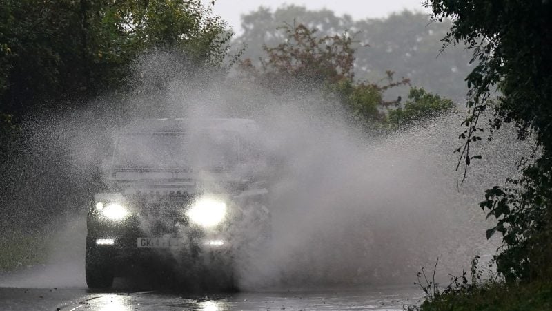 Unwetter in Großbritannien: Ein Auto fährt über eine überflutete Straße.