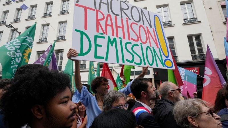 «Rücktritt von Macron - Verrat» wird auf einem Plakat auf einer Demonstration in Paris gefordert.