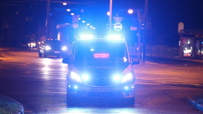 Ein Polizeiauto mit Blaulicht sperrt in Krefeld eine Straße ab.