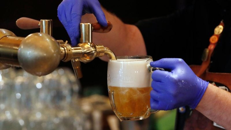 Ein Barkeeper zapft ein Bier auf einer Restaurant-Terrasse. (Symbolbild)