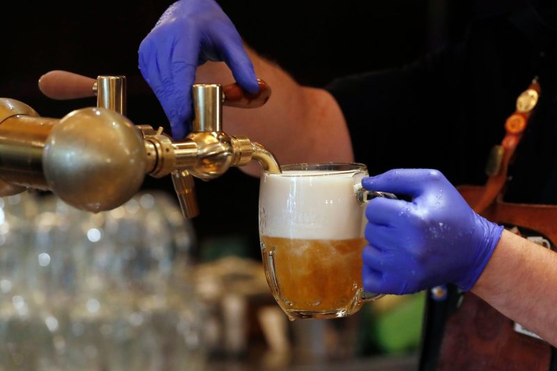 Ein Barkeeper zapft ein Bier auf einer Restaurant-Terrasse. (Symbolbild)