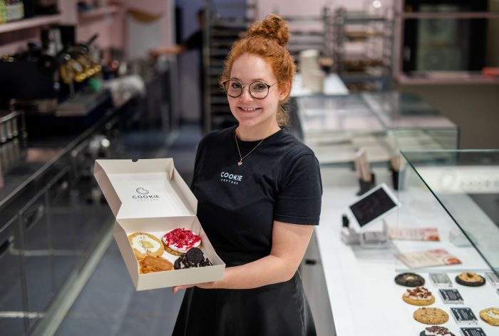 Eine Box mit frisch gebackenen und belegten Cookies präsentiert Mitgründerin Julia Boes.