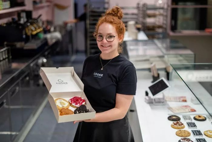 Eine Box mit frisch gebackenen und belegten Cookies präsentiert Mitgründerin Julia Boes.