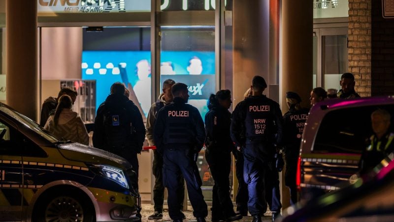 Polizeibeamte und Rettungsdienst stehen vor dem Kino in der Krefelder Innenstadt.