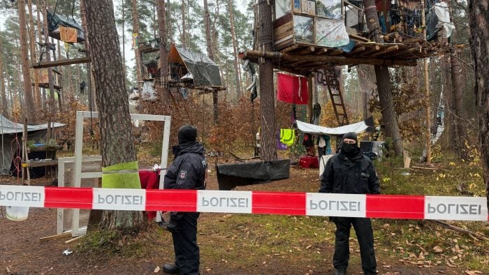 Polizeikräfte sichern das Waldgebiet hinter einer Absperrung. Umweltaktivisten, die gegen Tesla protestieren, müssen ihr Camp räumen. 