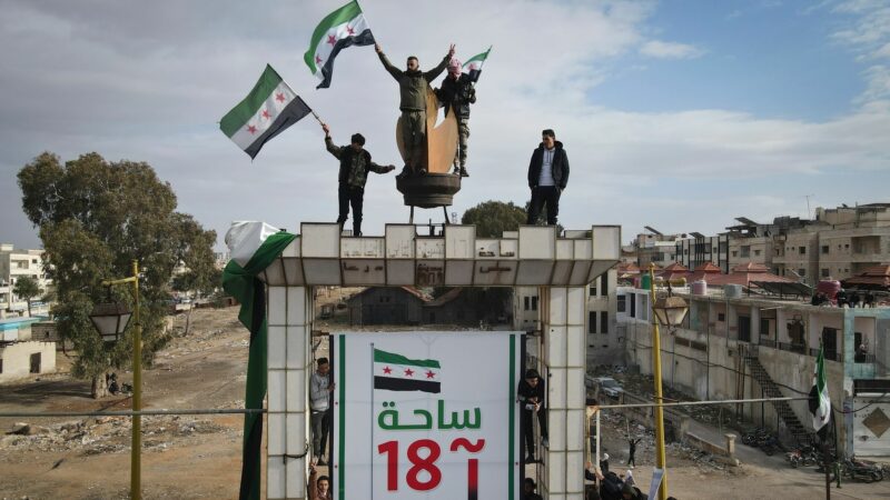 Syrer schwenken nach dem Freitagsgebet während einer Demonstration in Daraa Fahnen, um den Sturz der Regierung von Assad zu feiern.