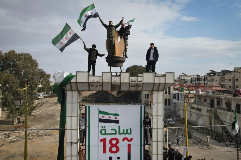 Syrer schwenken nach dem Freitagsgebet während einer Demonstration in Daraa Fahnen, um den Sturz der Regierung von Assad zu feiern.