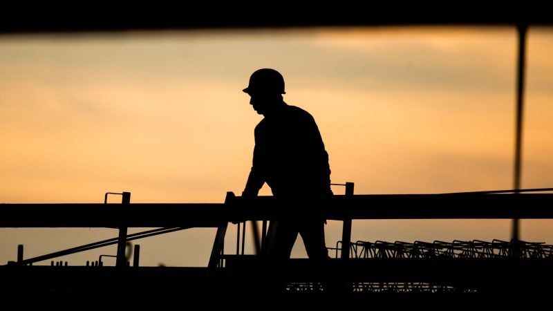 Ein Bauarbeiter in der Morgendämmerung. Laut Ifo-Beschäftigungsbarometer wollen viele Unternehmen Personal abbauen, in der Baubranche zeichnet sich jedoch keine größere Entlassungswelle ab.