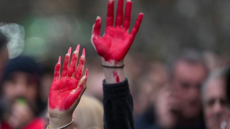 Frauen heben während einer Demonstration in Novi Sad ihre rot bemalten Hände.