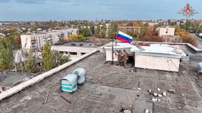 Russische Soldaten hissen in einer Ortschaft auf einem Gebäude eine Fahne nach dessen Einnahme. (Archivbild/Handout)