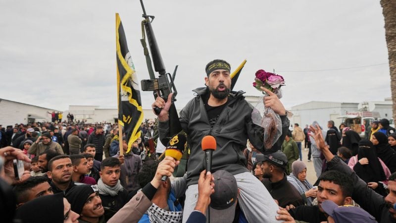 Der freigelassene palästinensische Häftling Hatem Kaider, 39, hält ein Gewehr und Blumen in der Hand, als er von einer jubelnden Menschenmenge im Gazastreifen begrüßt wird nach seiner Entlassung aus einem israelischen Gefängnis.