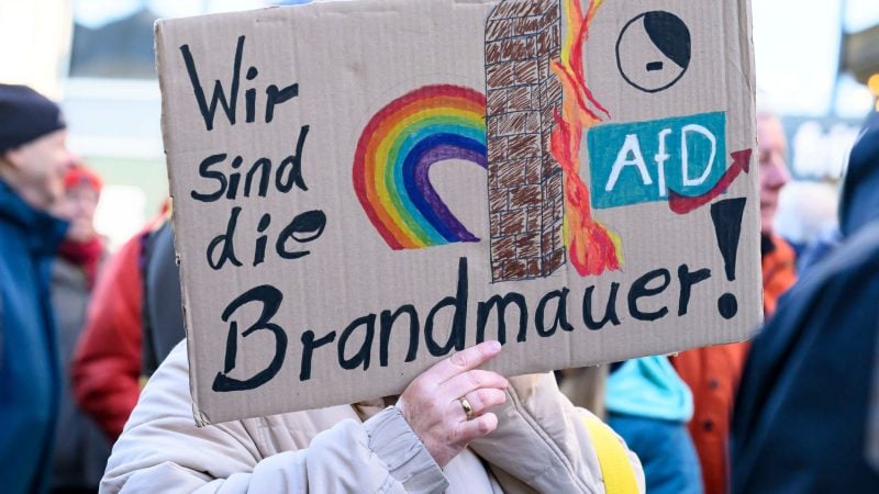 In Frankfurt erinnert eine Demonstrantin an die Brandmauer.