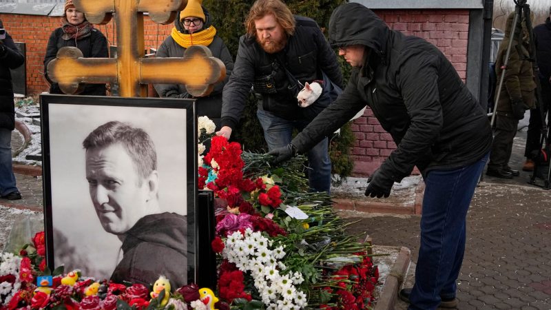 Menschen legen ein Jahr nach dem Tod des russischen Oppositionsführers Alexej Nawalny auf dem Borisowskoje-Friedhof in Moskau Blumen an seinem Grab nieder.