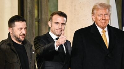 Ziehen in Sachen Ukraine-Politik nicht an einem Strang: der ukrainische Präsident Selenskyj (l.), Frankreichs Staatschef Macron und US-Präsident Trump. (Archivbild)