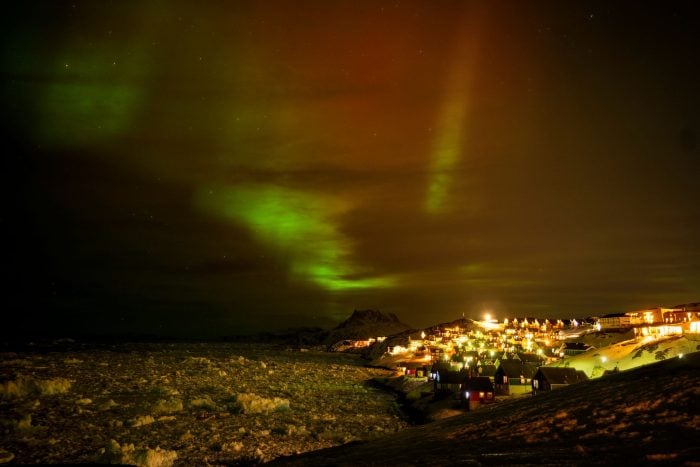 Polarlichter leuchten am frühen Donnerstagmorgen am Himmel über Häusern in Nuuk, Grönland.