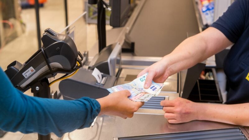 In einem Supermarkt hebt eine Kundin beim Bezahlen auch gleich Bargeld ab.