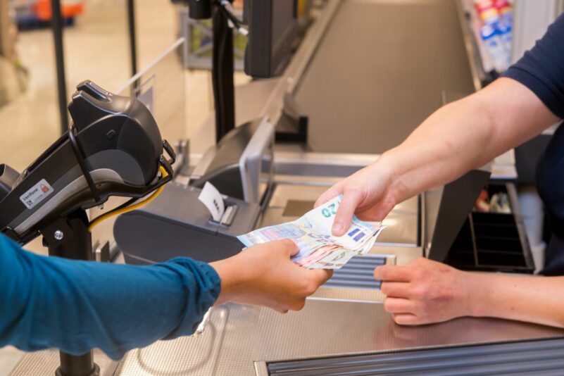 In einem Supermarkt hebt eine Kundin beim Bezahlen auch gleich Bargeld ab.