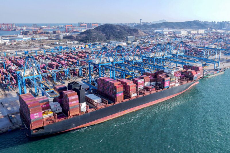 Cranes unload shipping containers from a ship at a port in Qingdao, in eastern China's Shandong province on April 2, 2025. US President Donald Trump ignited a potentially ruinous global trade war on April 2, as he slapped 10 percent tariffs on imports from around the world and harsh extra levies on key trading partners. (Photo by STRINGER / AFP) / China OUT (Photo by STRINGER/AFP via Getty Images)